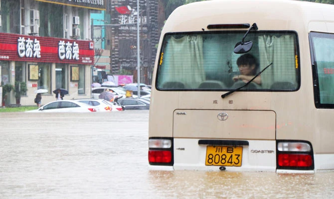 A woman looks on inside a stranded vehicle on a flooded street amid heavy rainfall, in Mianyang, Sichuan province, China July 11, 2018. (REUTERS)