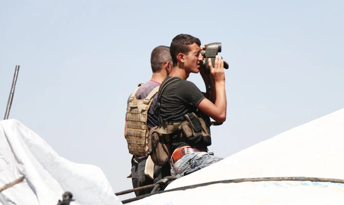 A Syrian rebel looks with binoculars during battles with pro-government fighters in western Daraa province on July 10, 2018. (AFP)