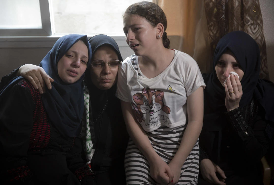 Relatives of 15-year-old Ameer Al-Nimra, who was killed along with another teenager on Saturday in an Israeli airstrike on Gaza, mourn during his funeral in the family home in Gaza City, Sunday, July 15, 2018. (AP/Khalil Hamra)