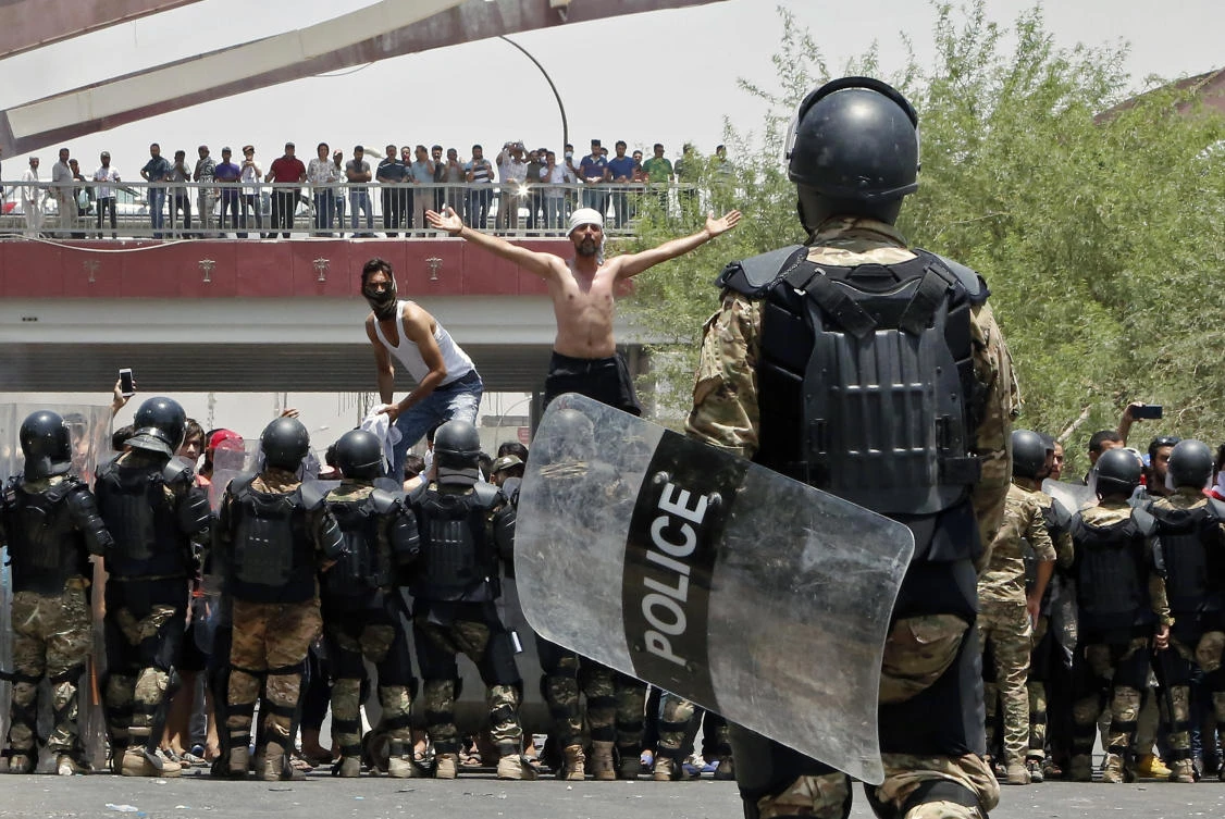 Iraqi riot police prevent protesters from storming the provincial council building during a demonstration in Basra, 340 miles (550 km) southeast of Baghdad, Iraq, Sunday, July 15, 2018. (AP Photo)