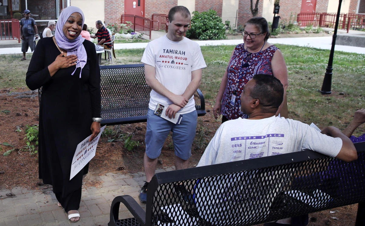 Attorney Tahirah Amatul-Wadud, left, who is challenging incumbent US Rep. Richard Neal, D-Mass., greets residents of an apartment complex while campaigning in Springfield. (AP/Charles Krupa)