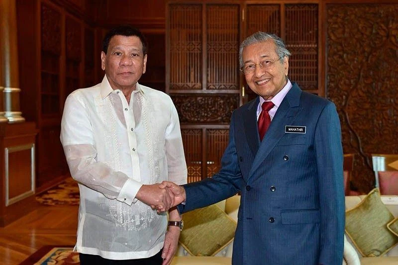 Philippine President Rodrigo Duterte is welcomed by Malaysian Prime Minister Mahathir Mohamad. (AP Photo)