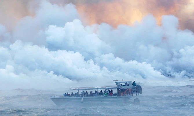 People watch from a tour boat as lava flows into the Pacific Ocean in the Kapoho area, east of Pahoa, during ongoing eruptions of the Kilauea Volcano in Hawaii, US, in this June 4, 2018 photo. (REUTERS)