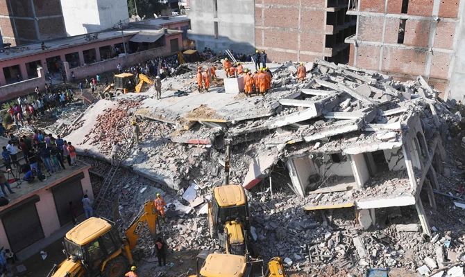 Members of the National Disaster Response Force (NDRF), along with local police, search for victims after an under construction building collapsed in the village of Shah Beri village in Greater Noida, a satellite town east of the Indian capital, in Uttar Pradesh on July 18, 2018. (AFP)