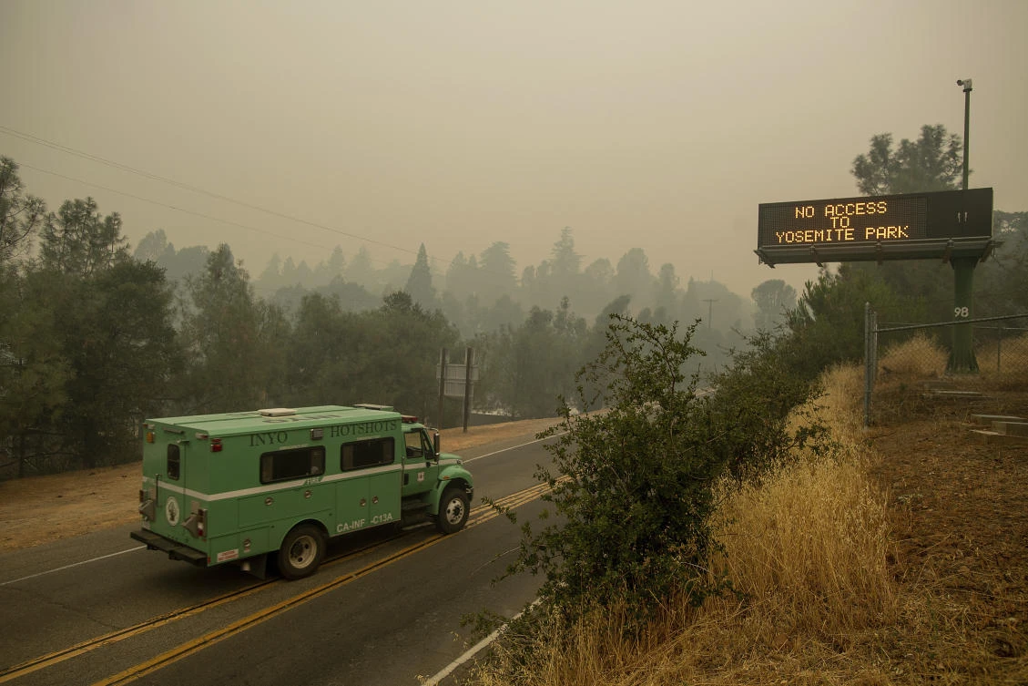 A fire transport drives along Highway 140, one of the entrances to Yosemite National Park, which remains closed as crews battle the deadly Ferguson wildfire. (AP)