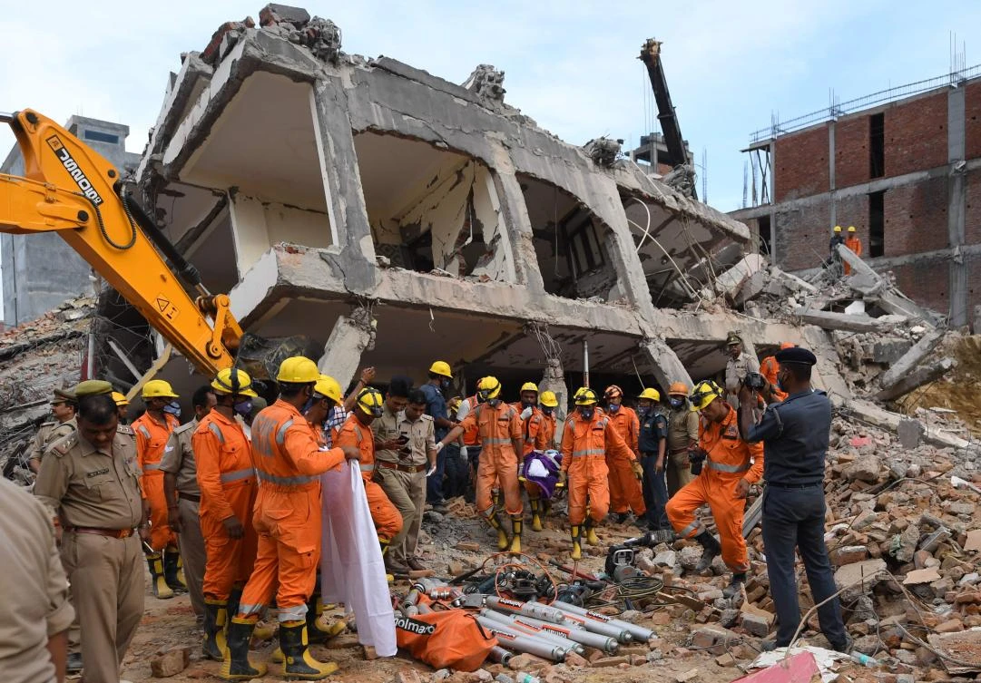 Members of the National Disaster Response Force carry out the body of a victim at the site of a collapsed building in Greater Noida. (AFP)