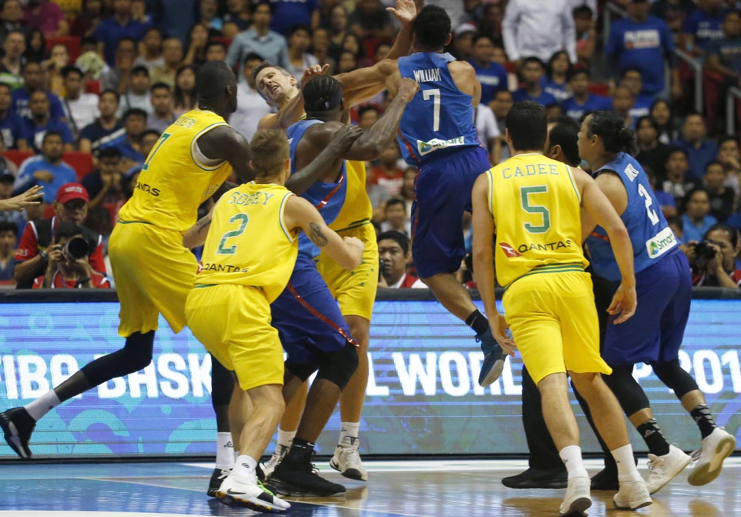 Philippines’ Jason William jumps to hit Australia’s Daniel Kickert, center left, as others rush to break a brawl during the FIBA World Cup qualifying basketball game on July 2, 2018. (AP)