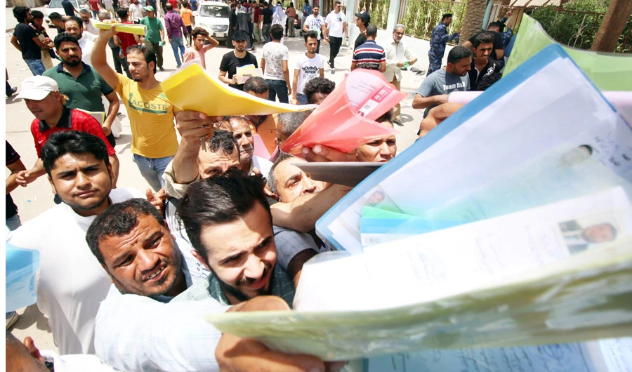 Protesters hand over job requests to government employees in Basra. (Reuters)