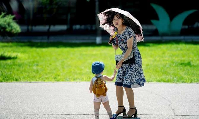 A woman and a young child walk down a street together in Pyongyang, North Korea, July 7, 2018. (REUTERS)