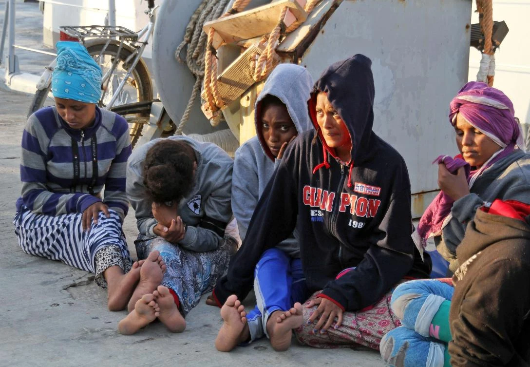 African migrants, who according to the Libyan navy were rescued by the country's coast guard, sit on a pier after arriving at the naval base in Tripoli on July 12. (AFP)