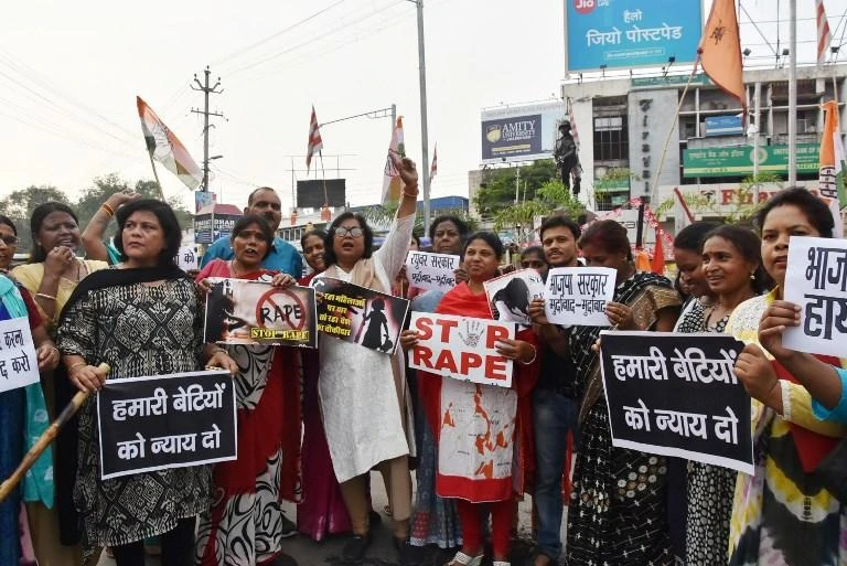 In this file photo, Indian National Congress party activists hold placards and shout slogans during a protest against the abduction and gang-rape of five charity workers in Chochang village of Khunti district, in Ranchi, India. (AFP)