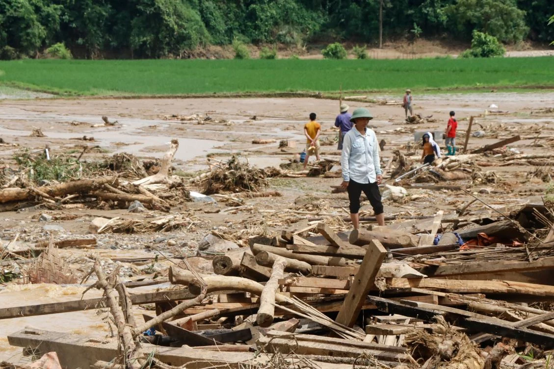 Residents clear debris in a village damaged by flash flooding in Vietnam’s Yen Bai province on July 21, 2018. (AFP)