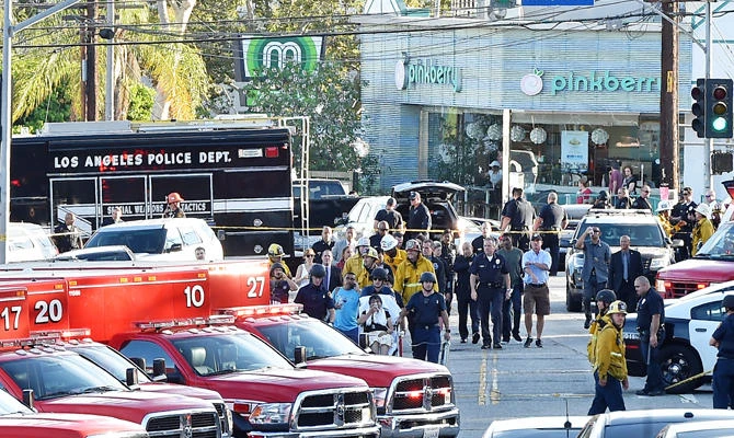 Police officers and members of the Los Angeles Fire Department escort a woman on a stretcher after a suspect barricaded inside a Trader Joe's supermarket in Silverlake, Los Angeles, on July 21, 2018. (AFP)