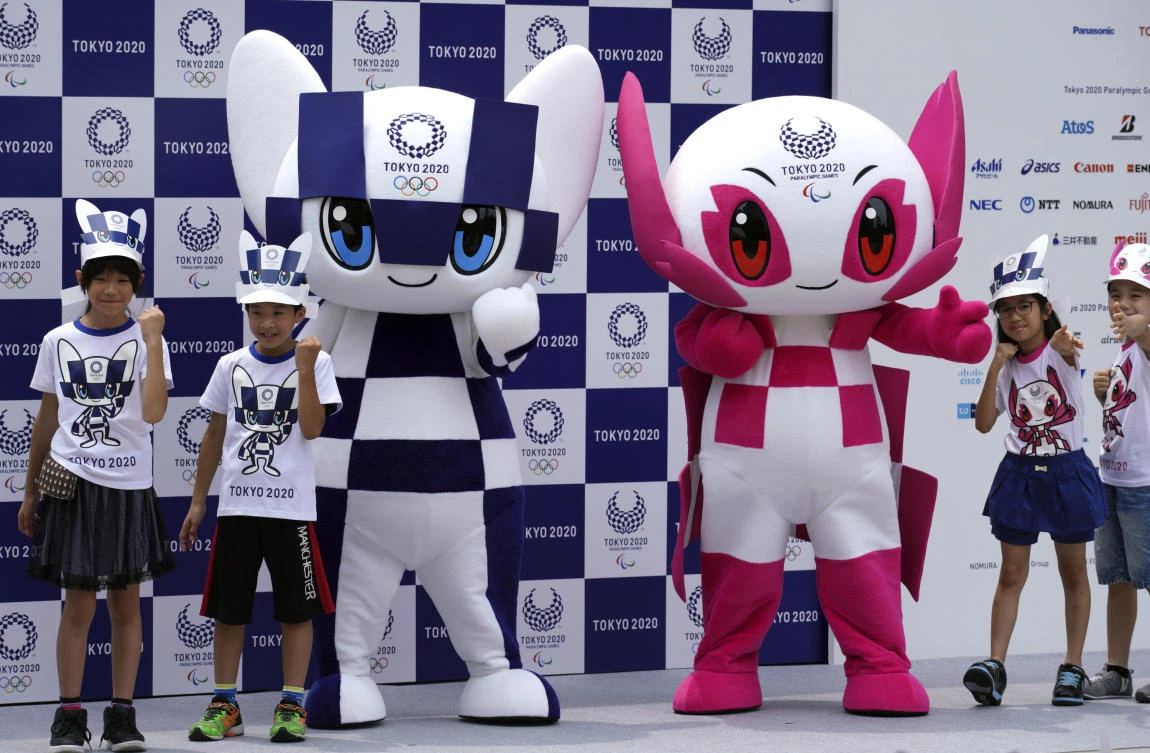 Tokyo 2020 Olympic mascot "Miraitowa", left, and Paralympic mascot "Someity", right, pose with children for photographers during the mascot debut event in Tokyo Sunday, July 22, 2018. (Eugene Hoshiko/AP)