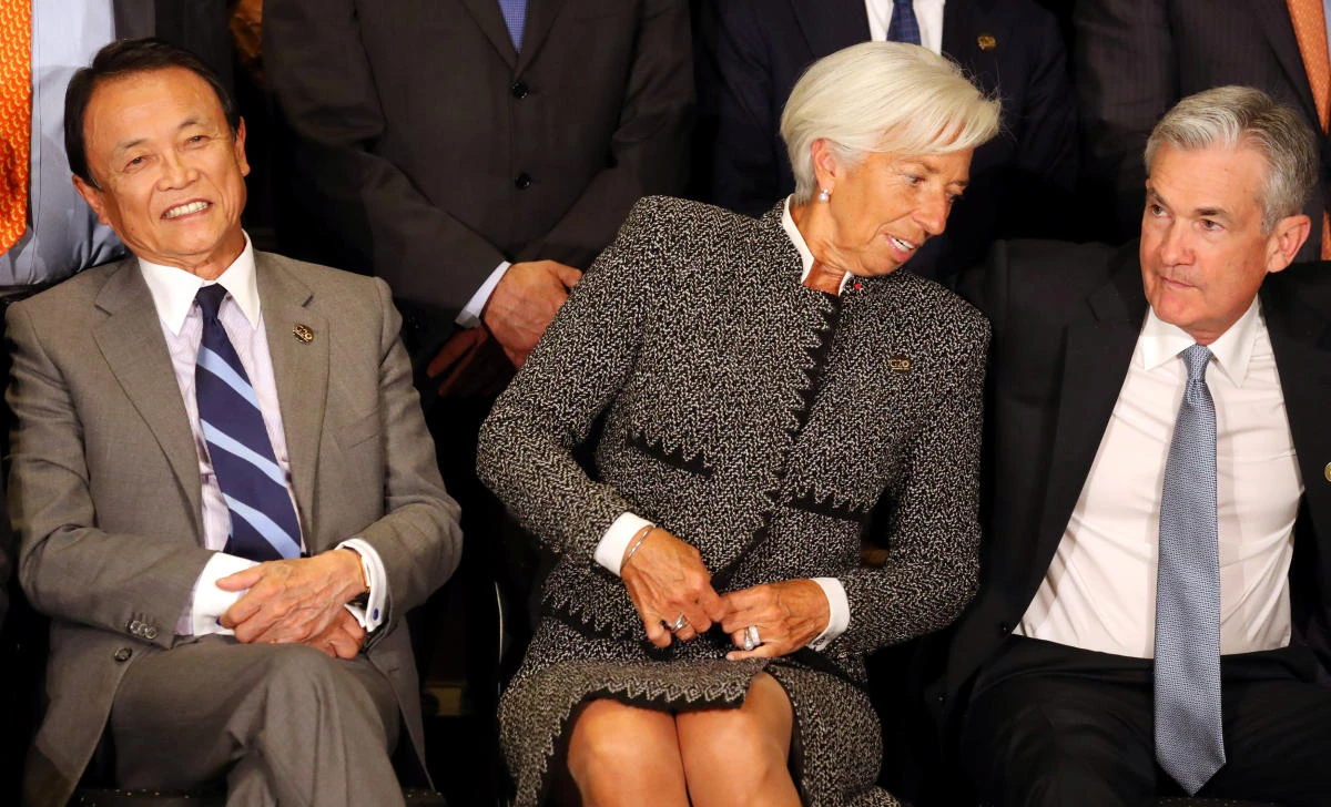 IMF Managing Director Christine Lagarde sits alongside Jerome Powell, Chairman of the U.S. Federal Reserve, and Japan's Minister of Finance Taro Aso as they pose for the official photo at the G20 Meeting of Finance Ministers in Buenos Aires, July 21, 2018. (REUTERS/Marcos Brindicci)