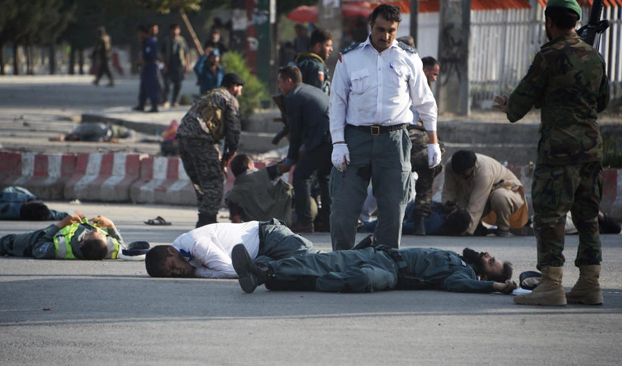 Afghan security forces stand near bodies of victims while others help injured people following a suicide attack in Kabul on July 22, 2018. (AFP / NOORULLAH SHIRZADA)