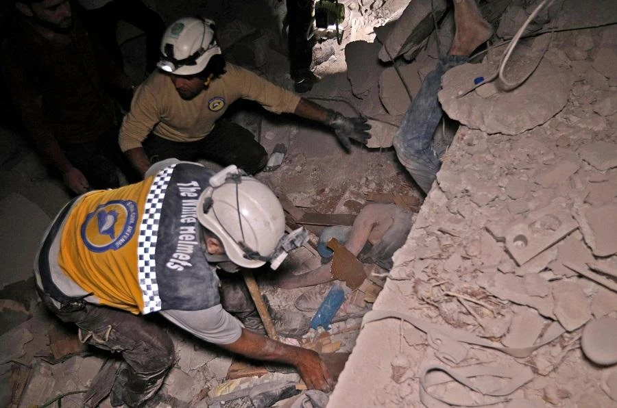 Syrian rescuers, known as White Helmets, recover bodies in Zardana, in the mostly rebel-held northern Syrian Idlib province, following air strikes in the area late on June 7, 2018. (AFP)
