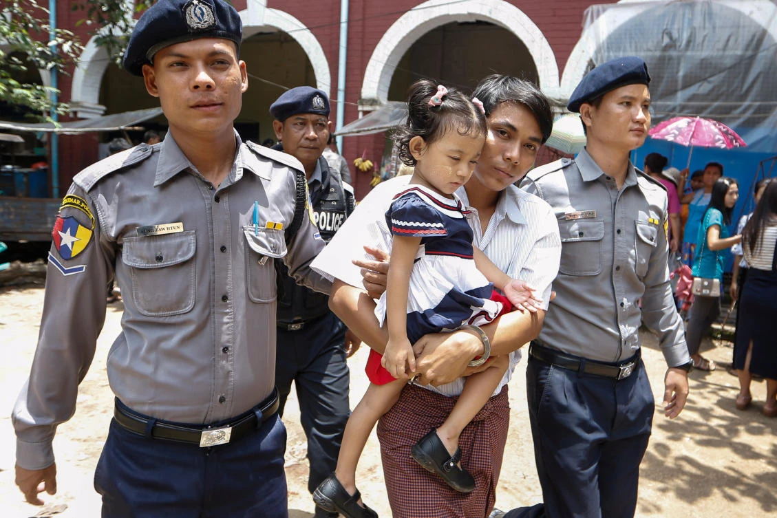 Detained Reuters journalist Kyaw Soe Oo holds his daughter as he leaves Insein court in Yangon, Myanmar, July 23, 2018. (Reuters)