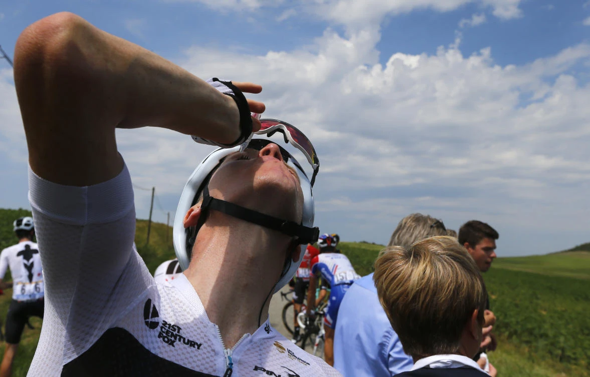 Britain's Chris Froome treats his eyes for tear gas sprayed on the peloton when a farmer's protest interrupted during the sixteenth stage of the Tour de France. (AP Photo/Peter Dejong)