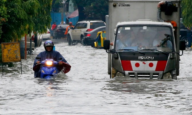 Vehicles negotiate a flooded street in Manila after overnight southwest monsoon rains brought about by tropical storm Ampil inundated low-lying areas in metropolitan Manila and nearby provinces on July 20, 2018 in Manila, Philippines.(AP Photo/Bullit Marquez)