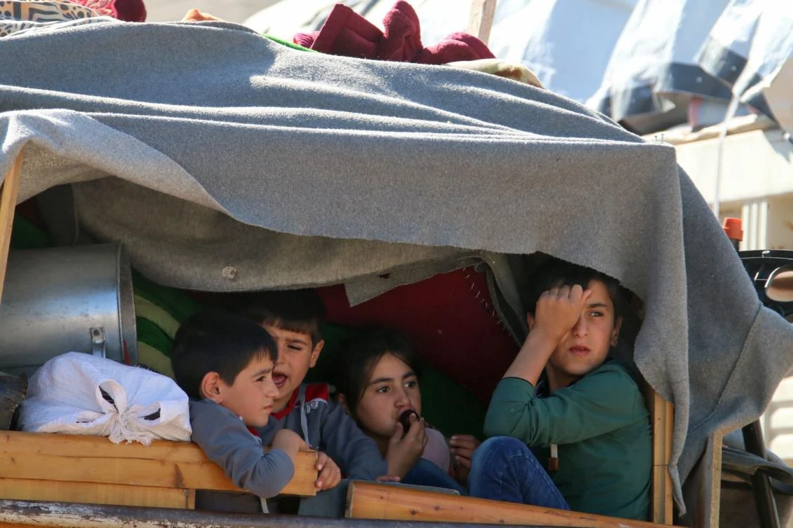 Syrian children ride a truck carrying their personal belongings at a Lebanese army checkpoint in Wadi Hmeid in the Bekaa valley, after leaving the village of Arsal to return to their homes in Syria's Qalamoun region on July 23, 2018. (AFP)
