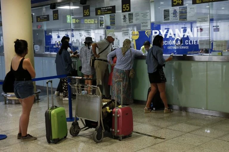 Passengers queue at a Ryanair customer service counter at El Prat airport in Barcelona on Wednesday, July 25, as the airline's cabin crew began a two-day strike. (AFP)