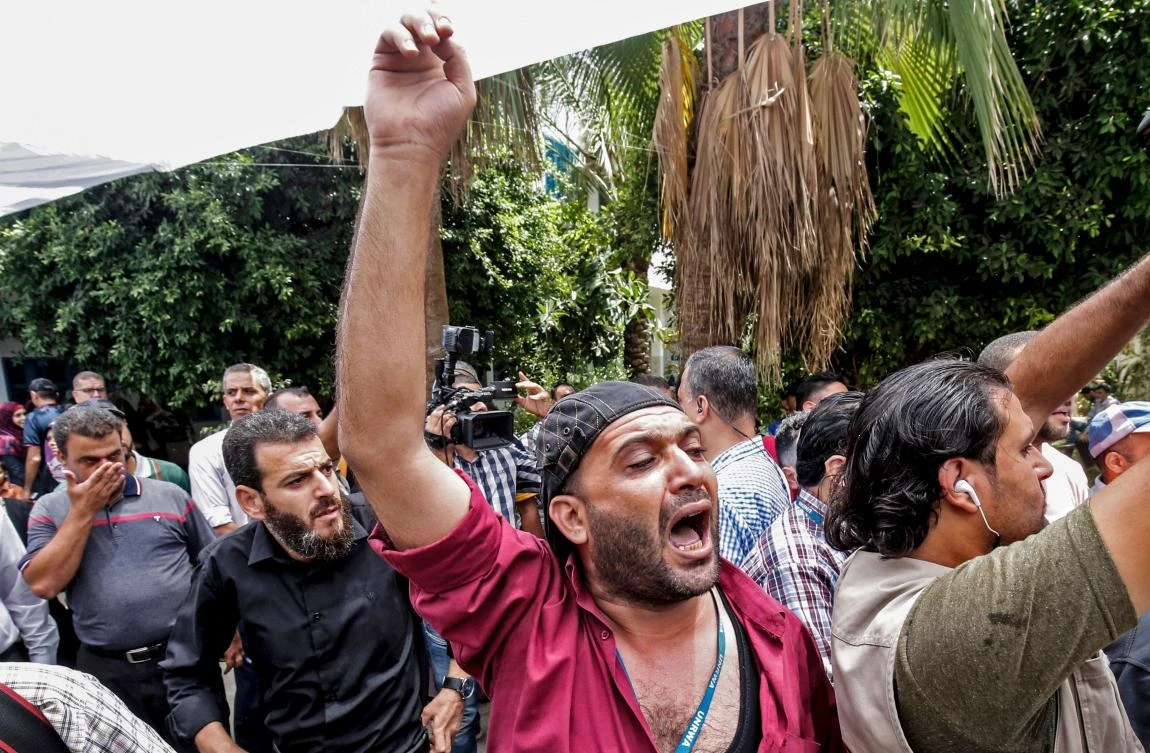 Palestinian employees of the United Nations agency for Palestinian refugees UNRWA take part in a protest against job cuts announced by the agency, at its headquarters in Gaza City July 25, 2018. (AFP)