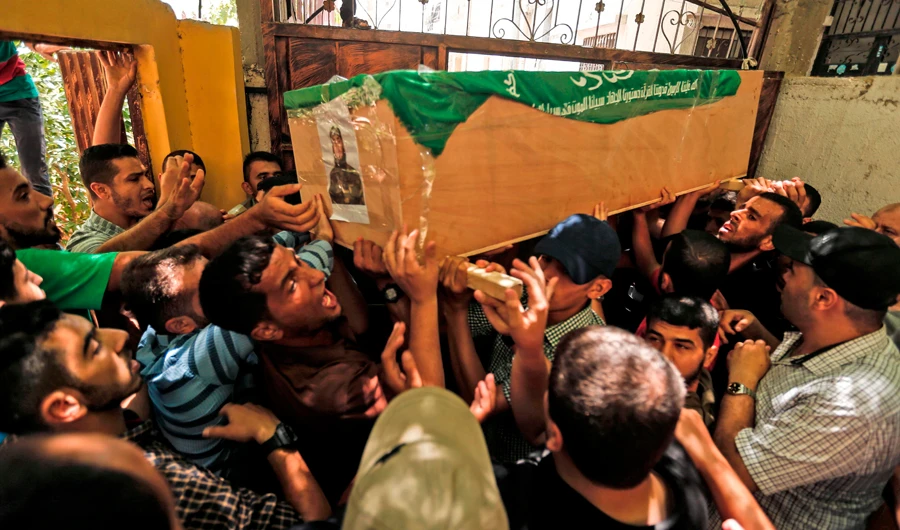 Palestinian mourners carry the body of Obada Farwana during his funeral in Gaza City on July 26, 2018. (AFP / MAHMUD HAMS)