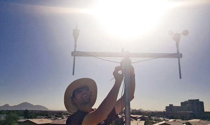 In this July 20, 2018 photo provided by Edison-Eastlake Measurement Campaign, David Hondula, Assistant Professor in the School of Geographical Sciences and Urban Planning at Arizona State University and a faculty affiliate of the Urban Climate Research Center, works on a weather station installation in the Aeroterra Apartment community in Phoenix. (AP)