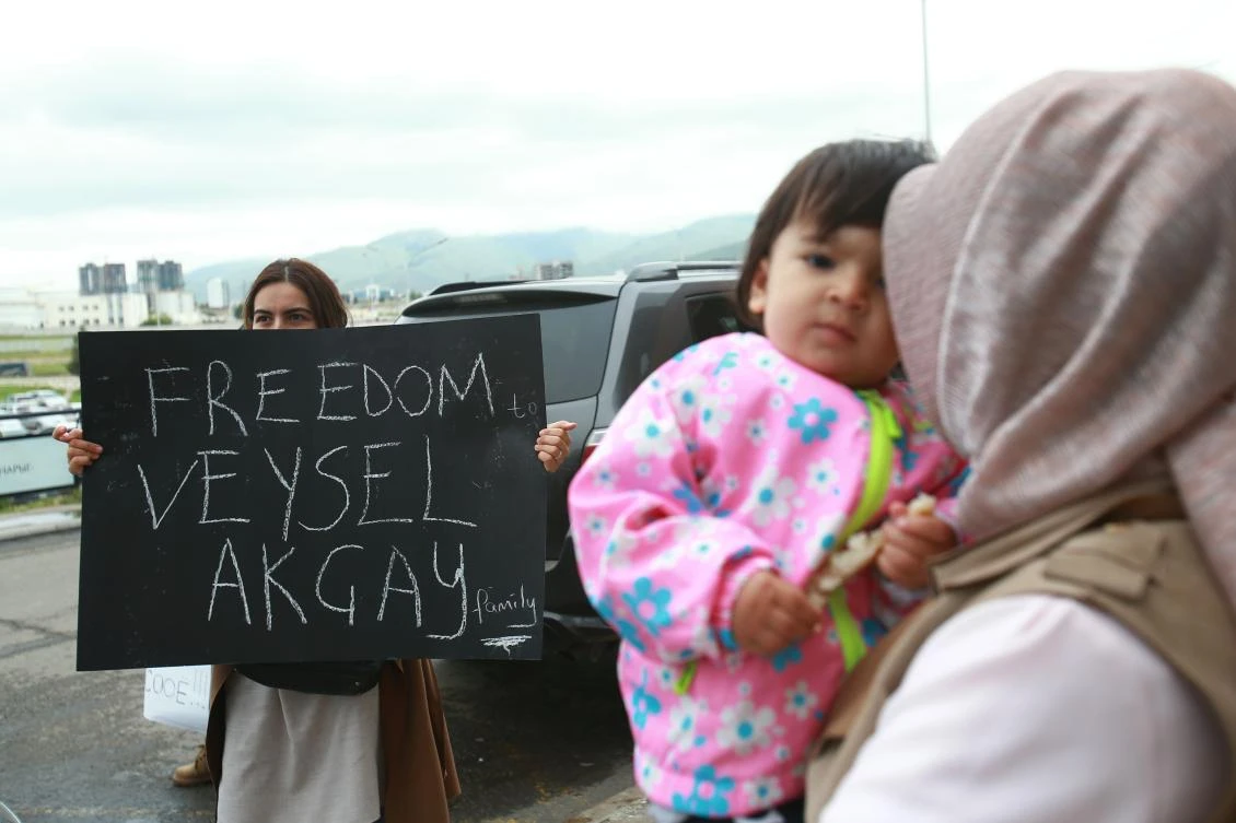 Students hold up banners in support of their teacher, Turkish school director Veysel Akcay, at the airport in Ulaanbaatar on July 27, 2018. (File/AFP/Byambasuren Byamba-Ochir)