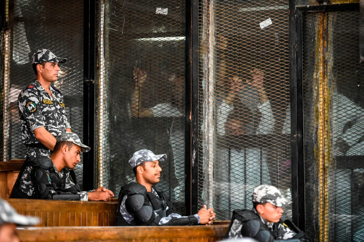 Members of Egypt’s banned Muslim Brotherhood are seen inside a glass dock during their trial in the capital Cairo on July 28, 2018. (AFP/Khaled Desouki)
