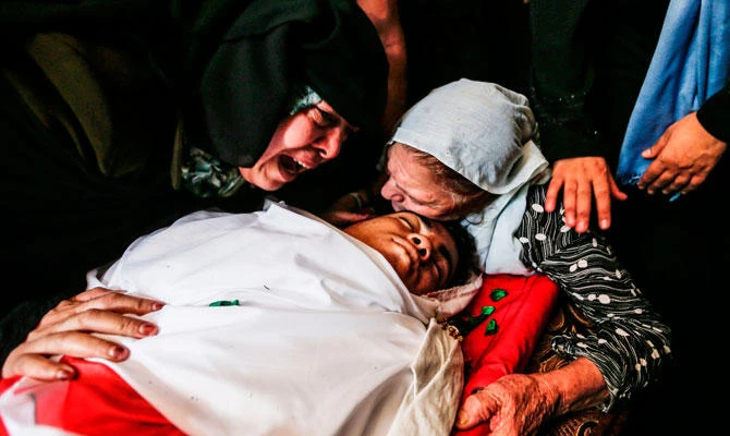 Relatives of 17-year-old Palestinian Momen al-Hams mourn over his body during his funeral in the Rafah refugee camp in the southern Gaza Strip on July 28, 2018, who died of wounds after being shot by Israeli troops. (AFP)
