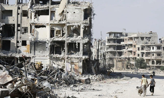 Syrian children walk by the rubble of destroyed buildings in Harasta, on the outskirt of the capital Damascus on July 15, 2018. (AFP)