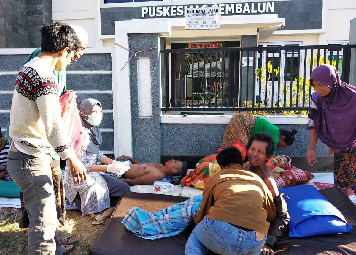 An Indonesia paramedic gives treatment to injured people outside of a hospital after an earthquake hit Sembalun Selong village in Lombok Timur, Indonesia, on Sunday. (Antara Foto/Zakir/via REUTERS)