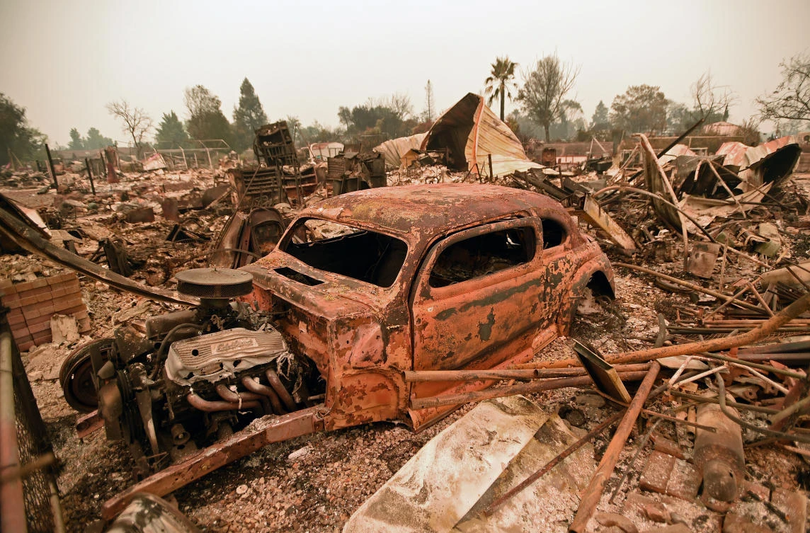 A destroyed car is seen among the ruins of a burned neighborhood after the Carr fire passed through the area of Lake Keswick Estates near Redding, California on July 28, 2018. (Josh Edelson/AFP)