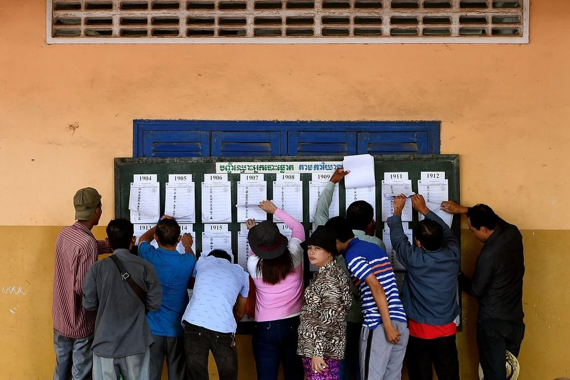 Cambodians check their names on a voters list at a polling station in Phnom Penh on July 29, 2018. (AFP)