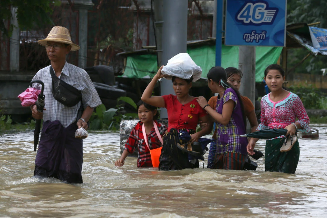 People wade through a flooded street in Bago, Myanmar, July 27, 2018. (REUTERS)
