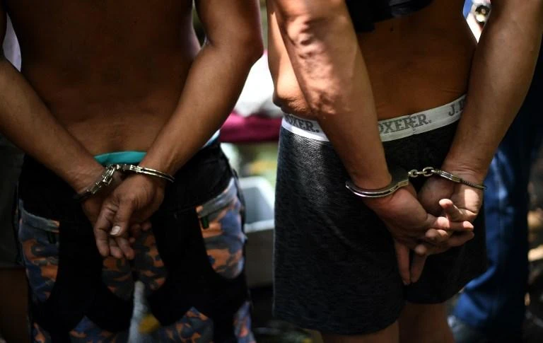 Two alleged drug dealers are handcuffed during a police operation conducted in Manila earlier this year. (AFP)