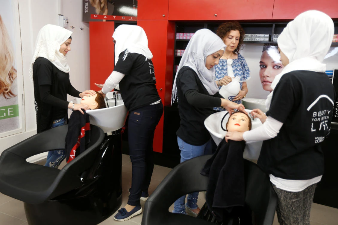 Women practice on hair mannequins at a training salon in Bar Elias town, in the Bekaa valley, Lebanon July 25, 2018. Picture taken July 25, 2018. (Reuters)