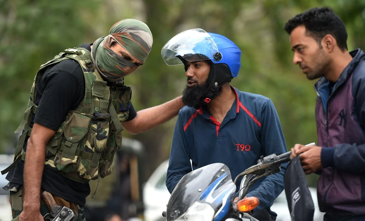 An Indian police from Special operation Group (SOG) questions a Kashmiri motorcyclist during a random search operation in central Srinagar on July 26, 2018. (TauseefMustafa/AFP)