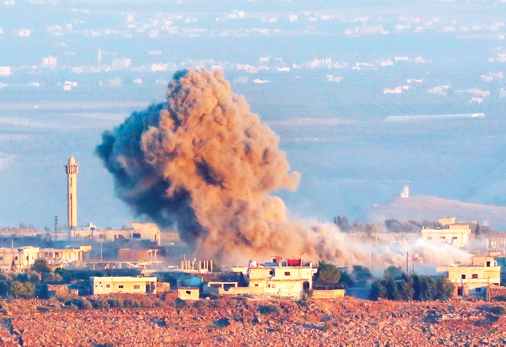 Smoke rises above buildings across the border during a regime-led offensive in Quneitra, Syria. (AFP)