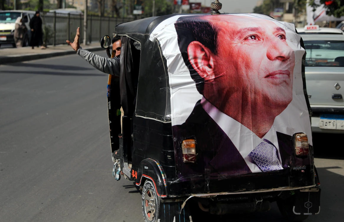 A man gestures as he rides a motorized vehicle showing a poster of Egyptian President Abdel Fattah al-Sisi during the second day of the presidential election in Cairo, Egypt, March 27, 2018. (Reuters)