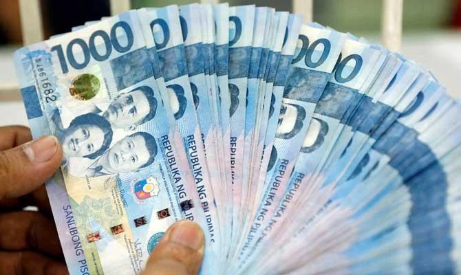 A worker shows Philippine peso bills inside a money changer in metro Manila, Philippines, in this August 14, 2017 file photo. (REUTERS)