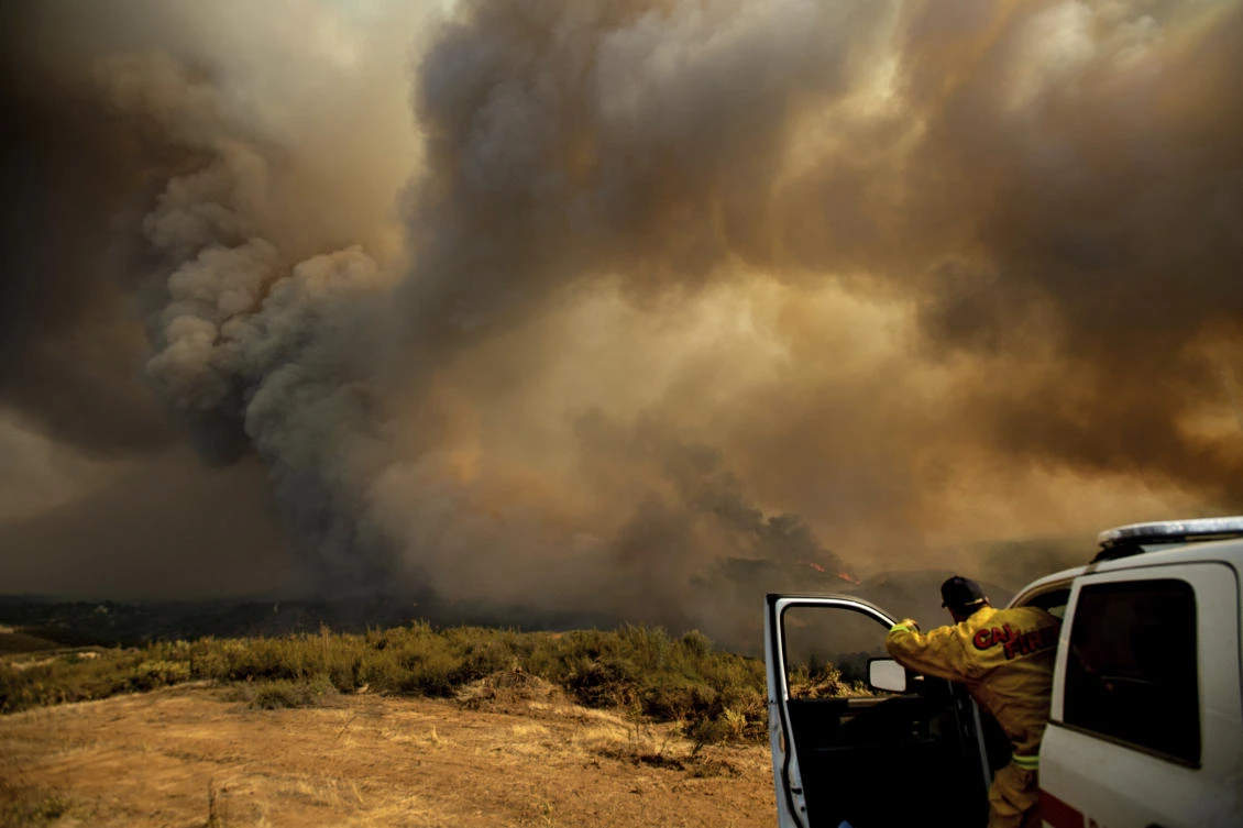 California Fire Division Chief Mark Higgins directs helicopters dropping water as the River Fire burns in Lakeport, California. (AP)