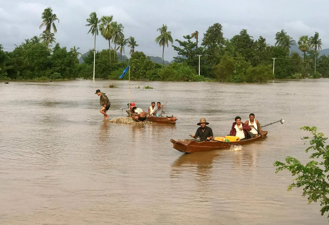 Villagers from near Hpa-an, the capital of Myanmar’s Karen state, travel across floodwaters on small boats to a waiting relief boat (not pictured) to pick up food and other emergency supplies. (AFP)