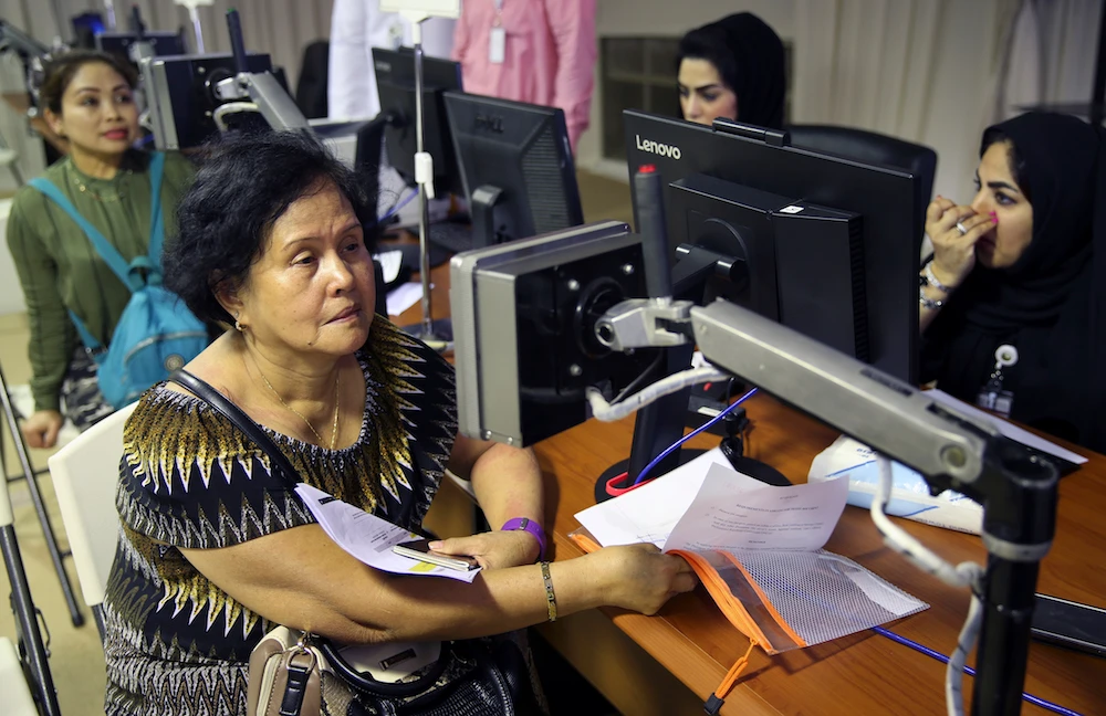 Filipino workers have their eyes scanned at a visa processing center near Dubai. (AP)