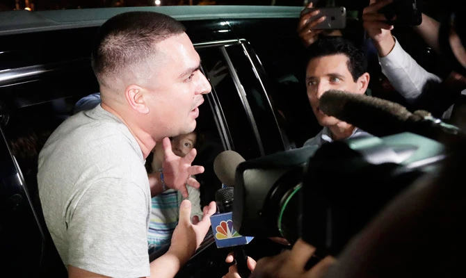One of Pablo Villavicencio's daughters, center, looks at her dad while he leans out of an SUV while talking to reporters after he was released from the Hudson County Correctional Facility, in this July 24, 2018 photo, in Kearny, N.J. (AP)