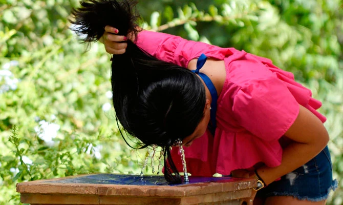A girl refreshes herself in a fountain on a hot summer day in Sevilla, on August 1, 2018 as a heatwave hits Spain and Portugal. (AFP)