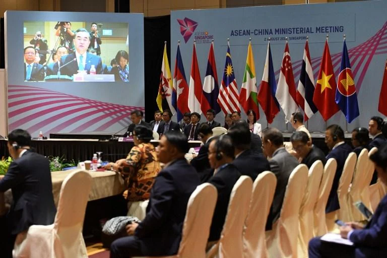 Tensions have escalated in recent years due to Beijing building artificial islands that can host military bases. Above, Chinese Foreign Minister Wang Yi, on screen, delivers his opening statement at the ASEAN summit in Singapore. (AFP)