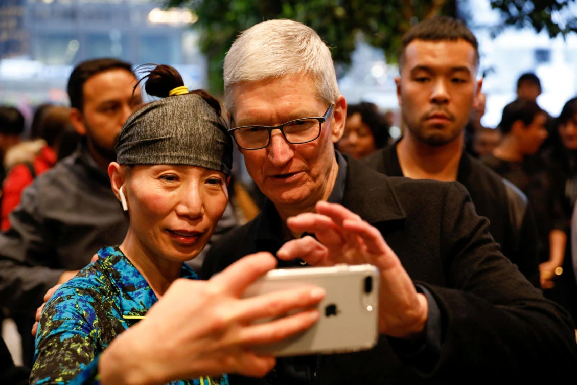Apple CEO Tim Cook takes a selfie with a customer at the Apple Store in Chicago, Illinois. (Reuters)